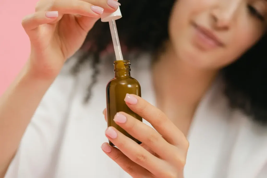 plicación de aceite de árbol de té en una espinilla para tratar el acné naturalmente.
