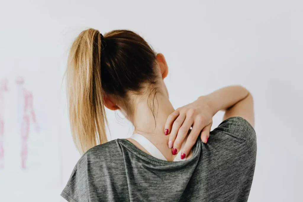 Persona con dolor en cuello y espalda debido a la tensión muscular causada por la ansiedad.