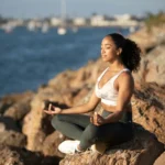 Persona meditando al aire libre con expresión de calma y concentración