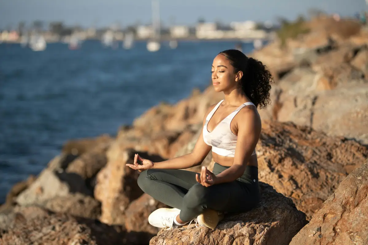 Persona meditando al aire libre con expresión de calma y concentración