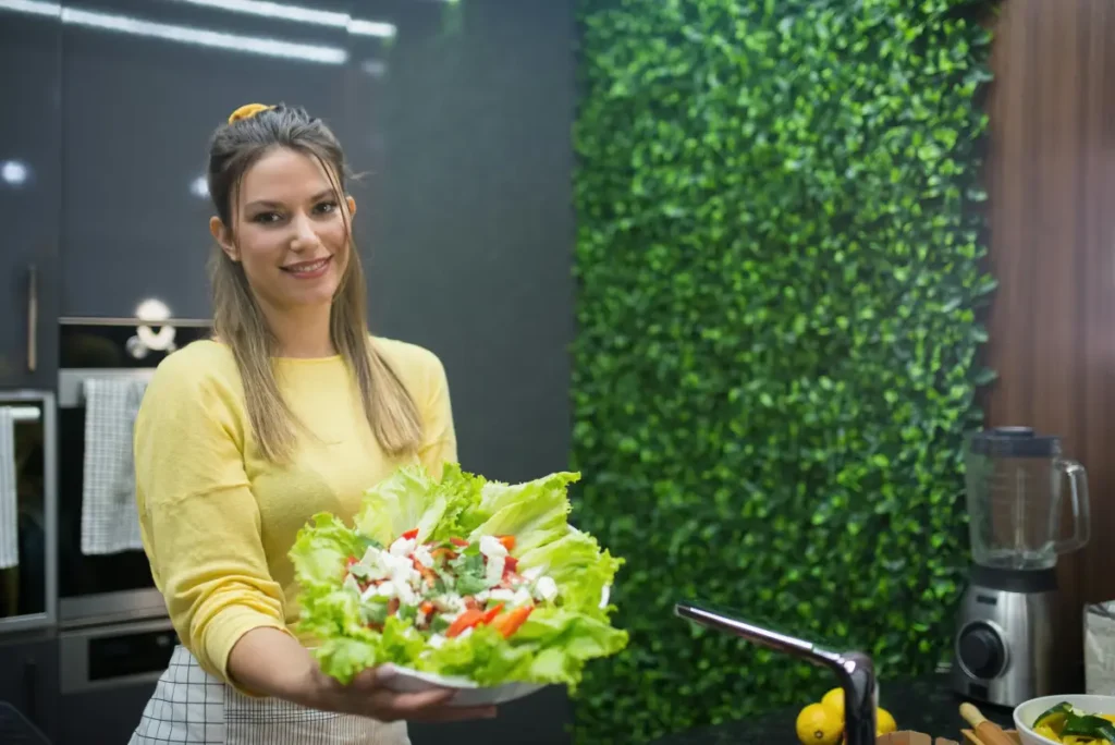 Persona feliz y saludable disfrutando de una ensalada fresca, con una apariencia enérgica y vital.
