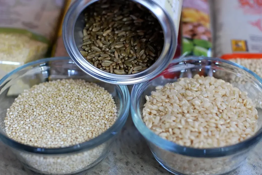 Variedad de cereales integrales como avena, arroz integral y quinoa, esenciales para una alimentación equilibrada."
