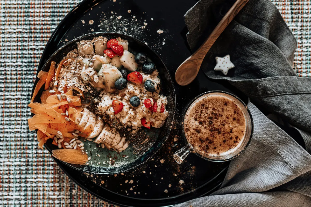 Desayuno saludable con frutas, avena y café para empezar el día con energía"