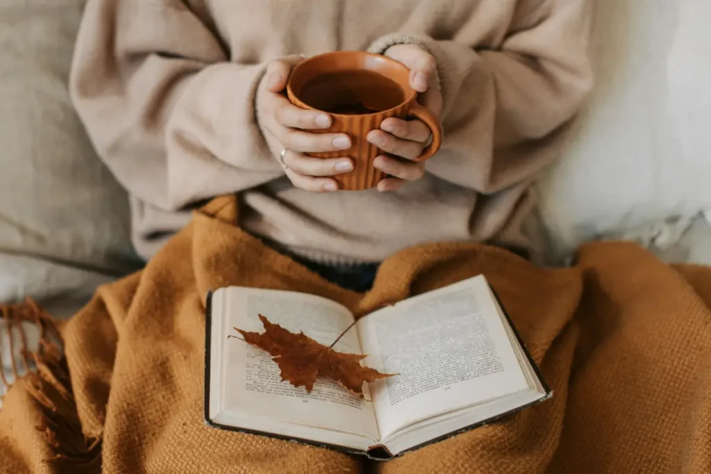 Mujer relajada con una taza de té, representando la importancia del descanso y el autocuidado para reducir el estrés.