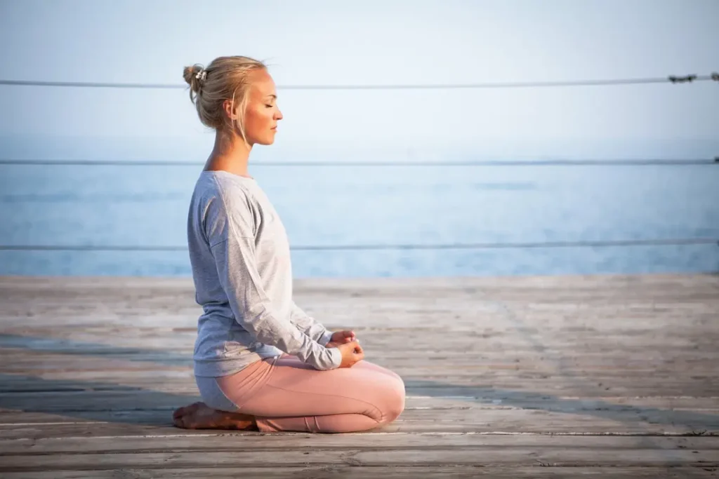 Mujer practicando meditación para reducir el estrés y mejorar la pérdida de peso.”