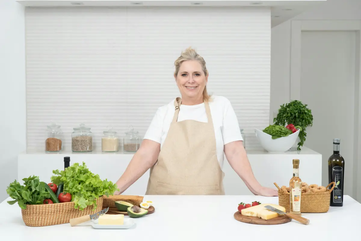 Una mesa con alimentos saludables antiinflamatorios como frutas, verduras, pescado, frutos secos y aceite de oliva, dispuestos en un entorno limpio y armonioso.
