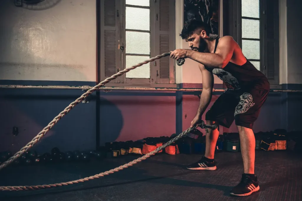 Hombre haciendo un entrenamiento HIIT en el gimnasio, combinando ejercicios de alta intensidad para maximizar la quema de calorías.