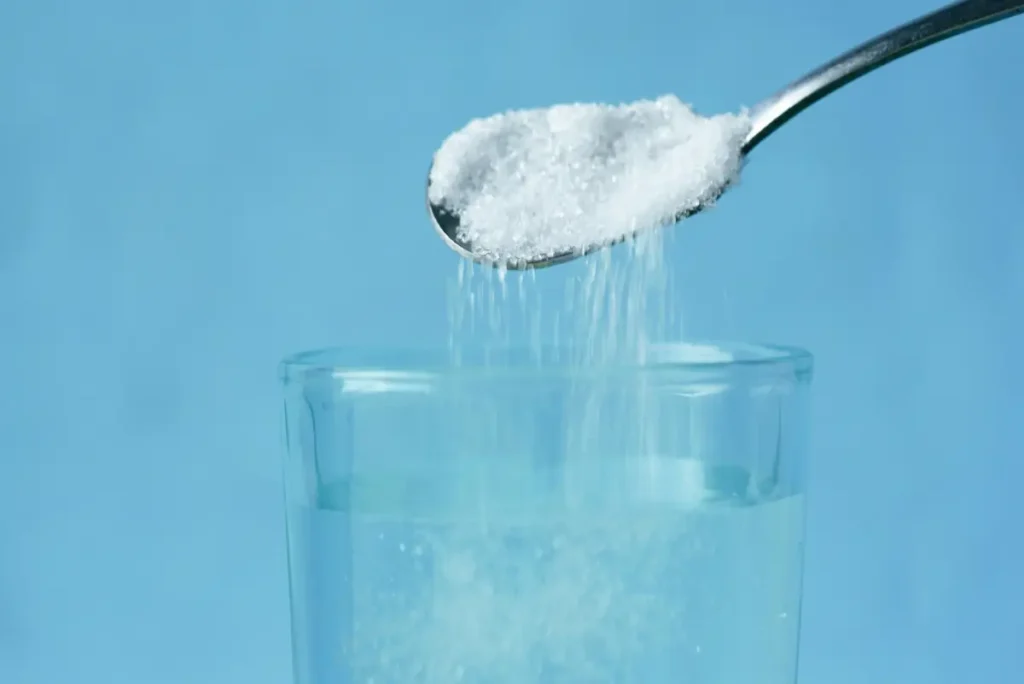 Persona haciendo gárgaras con agua salada para aliviar la tos y reducir la irritación de la garganta.