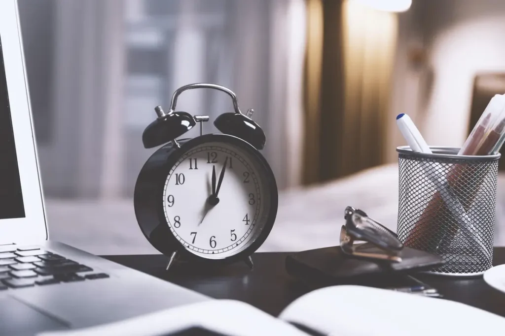 Reloj de escritorio y calendario destacando la importancia de gestionar el tiempo con la Técnica Pomodoro para reducir el estrés."