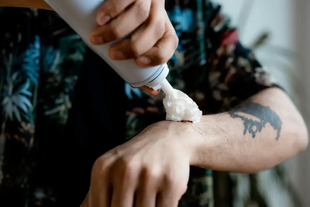 Aplicación de crema hidratante en un tatuaje recién hecho para mantener la piel nutrida.