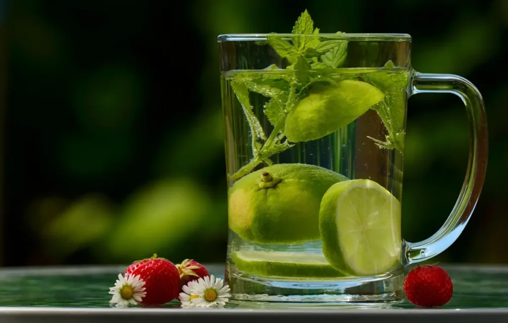 Un vaso de agua con frutas frescas para mantener la hidratación y la elasticidad de la piel.