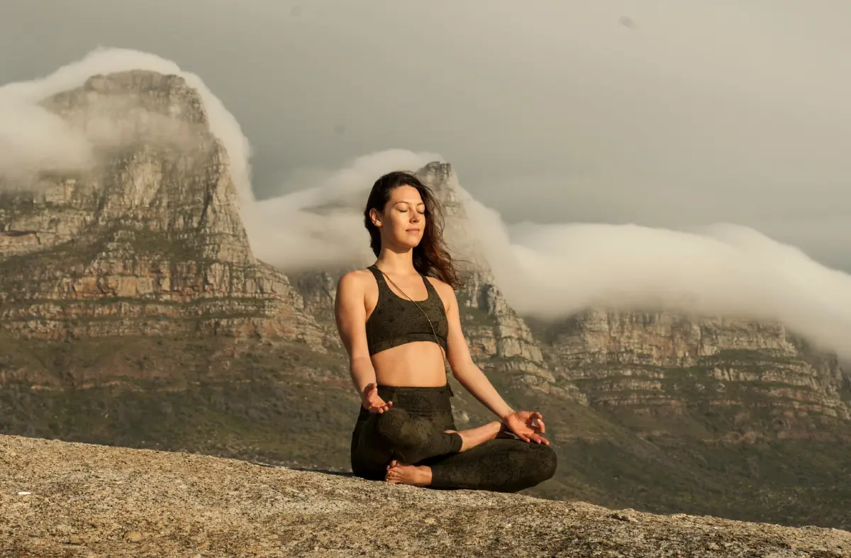 Persona practicando meditación en un entorno natural para reducir la ansiedad en un mundo acelerado.