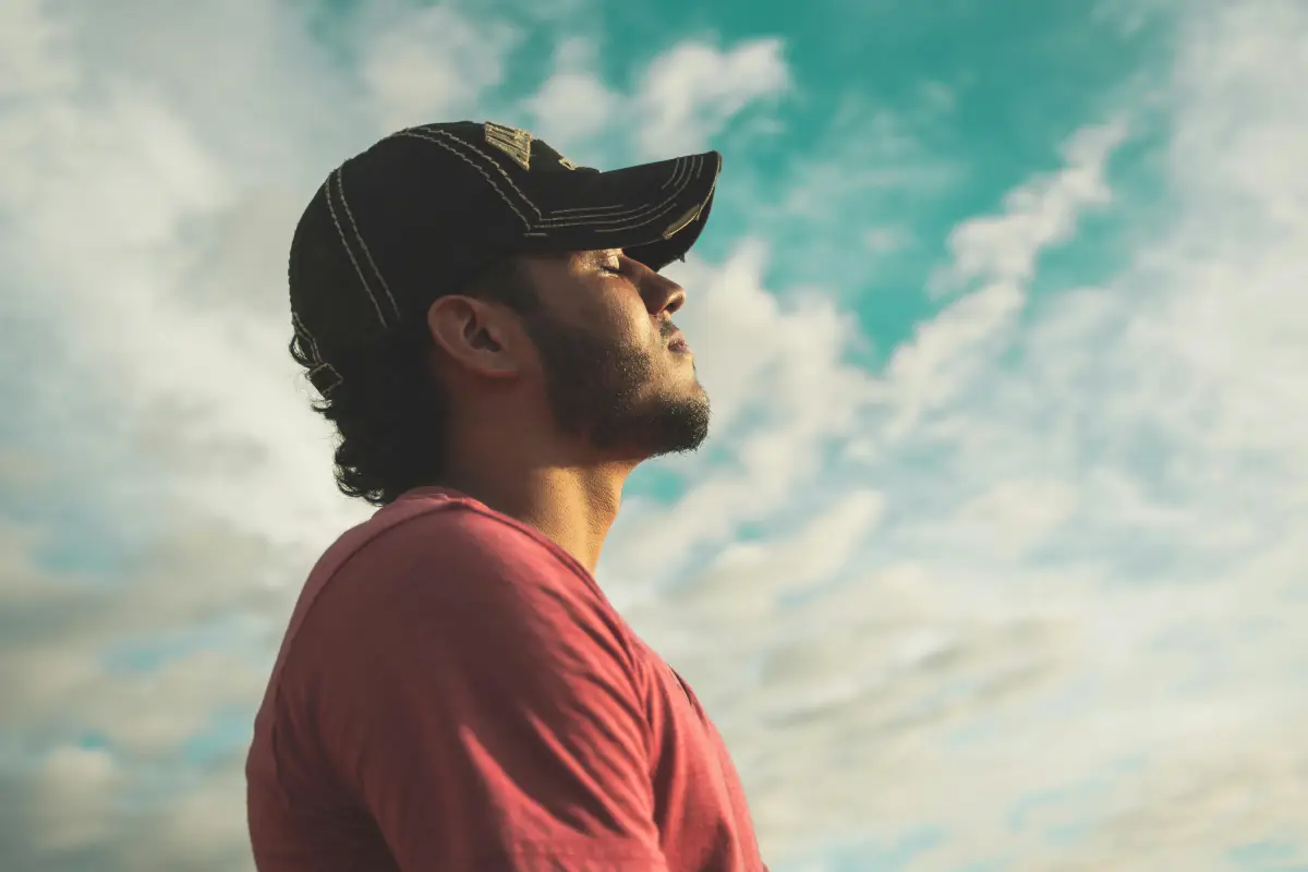 Primer plano de una persona con los ojos cerrados enfocándose en su respiración.