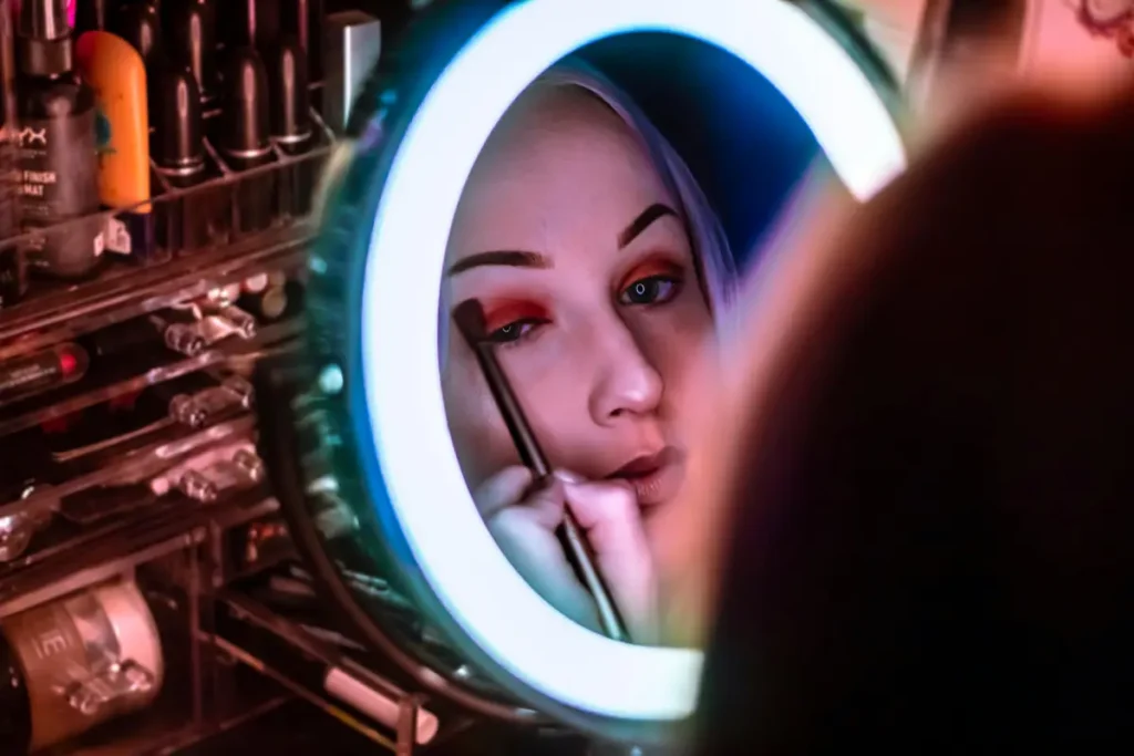 Mujer aplicando base de maquillaje con brocha para un acabado impecable.