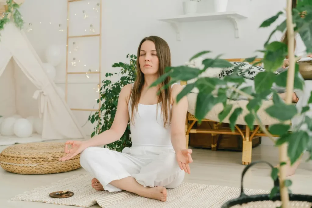 Mujer practicando mindfulness y meditación en casa para controlar el estrés y la ansiedad.