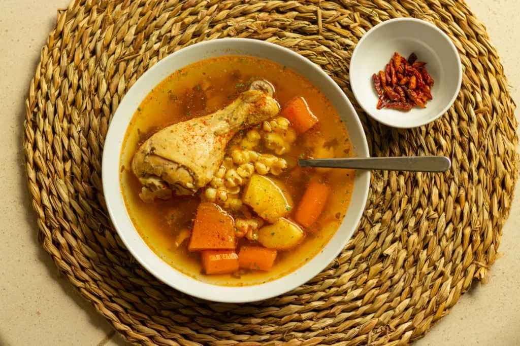 Plato de sopa de pollo caliente con verduras, ideal para aliviar los síntomas de la gripe.