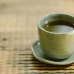 Té verde en taza blanca con hojas frescas, ideal para estimular el metabolismo y perder peso.