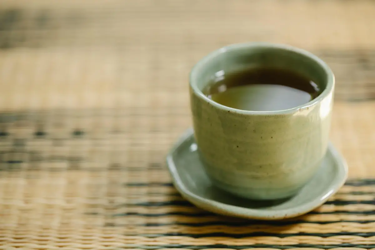 Té verde en taza blanca con hojas frescas, ideal para estimular el metabolismo y perder peso.